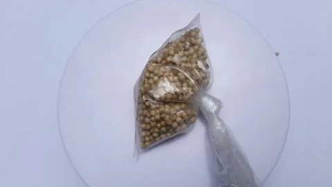 Cilantro in plastic wrap is placed on a rotating display Stock Footage 246631861