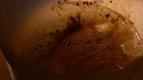 Cinamon powder falling. Close-up of mixer whipping milk smoothie with cinnamon Stock Footage 84022052