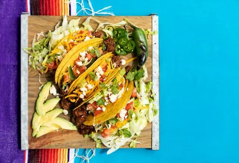 Cinco: Five Tacos On Board With Jalapenos And Avocado Stock Photos
