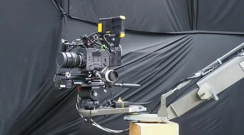 A cinema camera mounted on a mechanical camera crane, equipped with a high .. Stock Photos