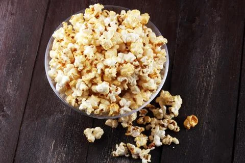 Cinema concept with popcorn on rustic table. Stock Photos