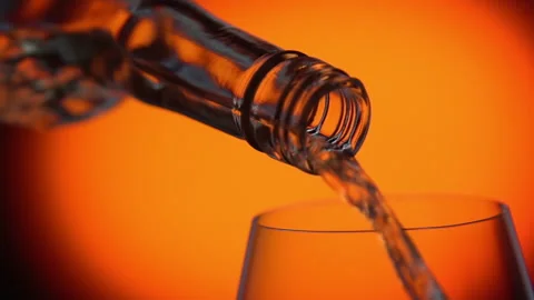 Cinema graph hard alcohol or wine pouring into glass orange spotted background Stock Footage 138568559