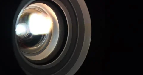 Cinema hall. Projector lens in operation. Movie is shown through projector. Lens Stock Footage 281009926
