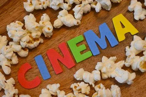 Cinema letters surrounded by popcorn Stock Photos