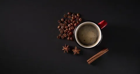 Cinemagrah loop. Steaming coffee mug with beans on dark background. Top view Stock Footage 122687936