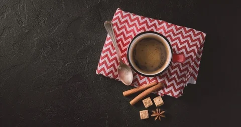 Cinemagrah loop. Steaming coffee mug with cinnamon sticks on red napkin. Top Stock Footage 122764757