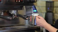 Barista Whisk Milk in Coffee Machine with Hot Steam Stock Footage