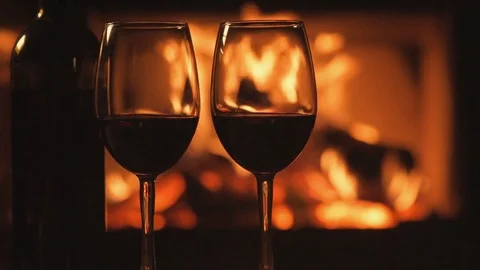 Cinemagraph - Bottle and two red wine wineglasses over a fireplace background. Stock Footage 82544275