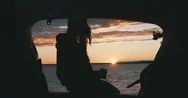 Cinemagraph -  Caucasian Female Sits On A Suv Trunk On A Lake During Sunset Stock Footage