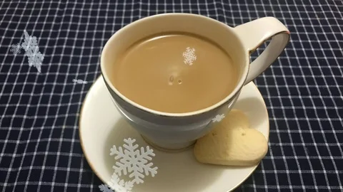 Cinemagraph -ed snow falling on the white cup of coffee with heart shaped cookie Stock Footage 100794415