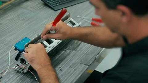 Cinemagraph of electrician assembles electrical equipment to a machine in a f Stock Footage 129549427
