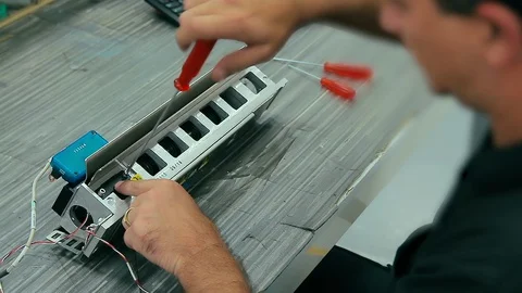 Cinemagraph of electrician assembles electrical equipment to a machine in a f Stock Footage 129549496