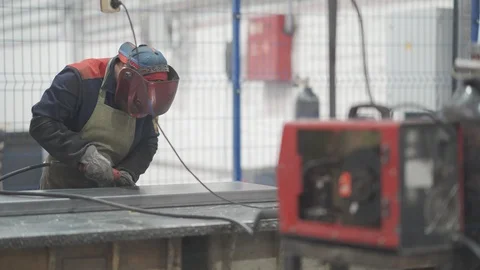 Cinemagraph of factory worker in protective mask welding metal material with Stock Footage