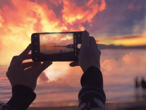 Cinemagraph framing orange sunset sea hands holding smartphone Stock Footage 114920962