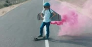 Cinemagraph Little Boy Wearing Styrofoam Wings Standing On A Skateboard Stock Footage