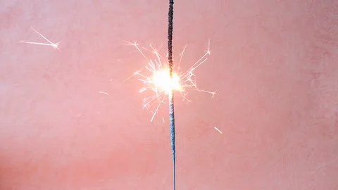 Cinemagraph loop: burning sparkler, orange background Stock Footage 103835970