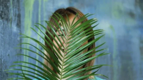 Cinemagraph loop of Charming cheerful blond hair female waves palm leaf Vídeo Stock 83386723