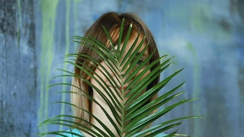 Cinemagraph loop of Charming cheerful blond hair female waves palm leaf Stock Footage 83386898