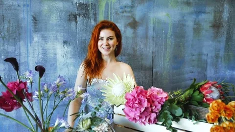 Cinemagraph loop of Charming red hair female shop assistant spins flower Stock Footage 83354704