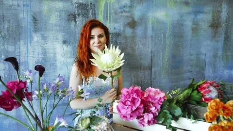 Cinemagraph loop of Charming red hair female shop assistant spins flower Stock Footage 83354981
