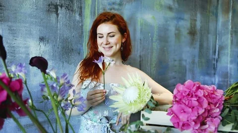 Cinemagraph loop of Charming red hair female shop assistant spins flower Stock Footage 83355004