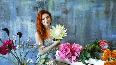 Cinemagraph loop of Charming red hair female shop assistant spins flower Stock Footage 83355005