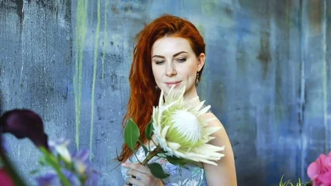 Cinemagraph loop of Charming red hair female shop assistant spins flower Stock Footage 83355489
