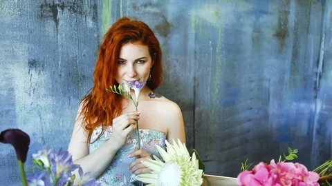 Cinemagraph loop of Charming red hair female shop assistant spins flower Stock Footage 83355654