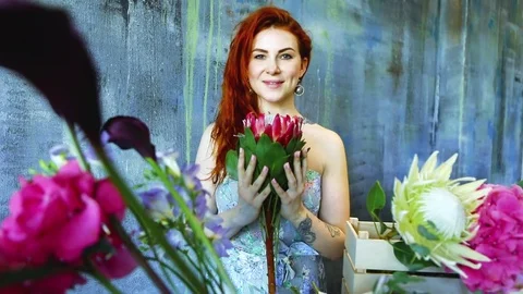 Cinemagraph loop of Charming red hair female shop assistant spins flower Stock Footage 83355799