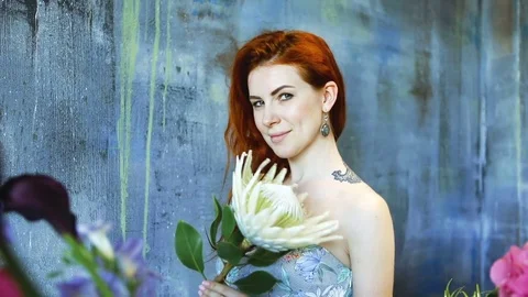 Cinemagraph loop of Charming red hair female shop assistant spins flower Stock Footage 83355963