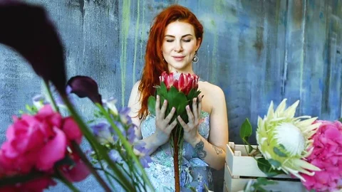 Cinemagraph loop of Charming red hair female shop assistant spins flower Vídeo Stock 83356251