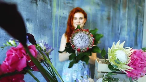 Cinemagraph loop of Charming red hair female shop assistant spins flower Stock Footage 83356900
