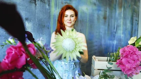 Cinemagraph loop of Charming red hair female shop assistant spins flower Stock Footage 83357023