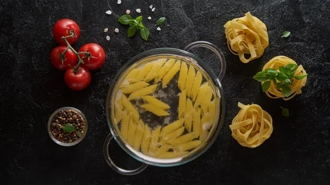 Cinemagraph loop. Cooking pasta penne in a glass pot with boiling water Stock Footage 107926506