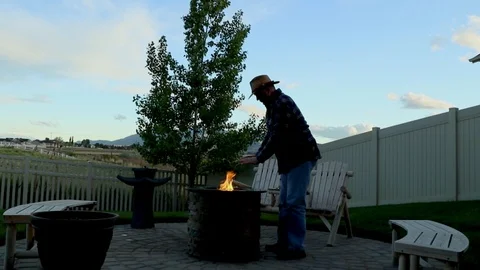Cinemagraph of a man warming his hands at a backyard firepit Stock Footage 89768671