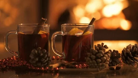 Cinemagraph - Mulled wine glasses on table in front of burning fireplace. Stock Footage 79873663