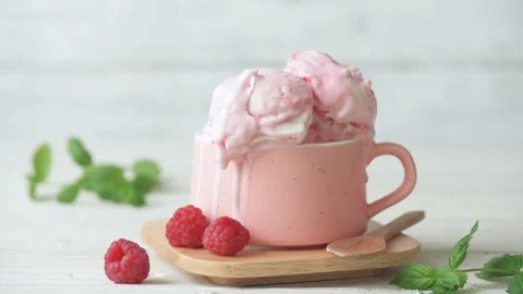 Cinemagraph - Raspberry ice cream in cup on wooden table. Stock Footage 98409990