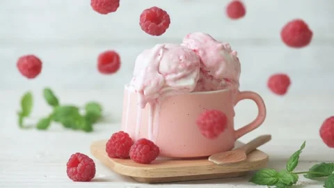 Cinemagraph - Raspberry ice cream in cup on wooden table. Stock Footage 98409995