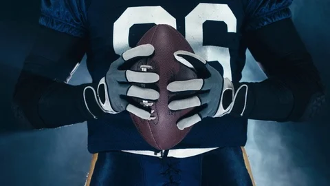 CINEMAGRAPH - seamless loop. EXTREME CU American football player holding a ball Stock Footage 73110447