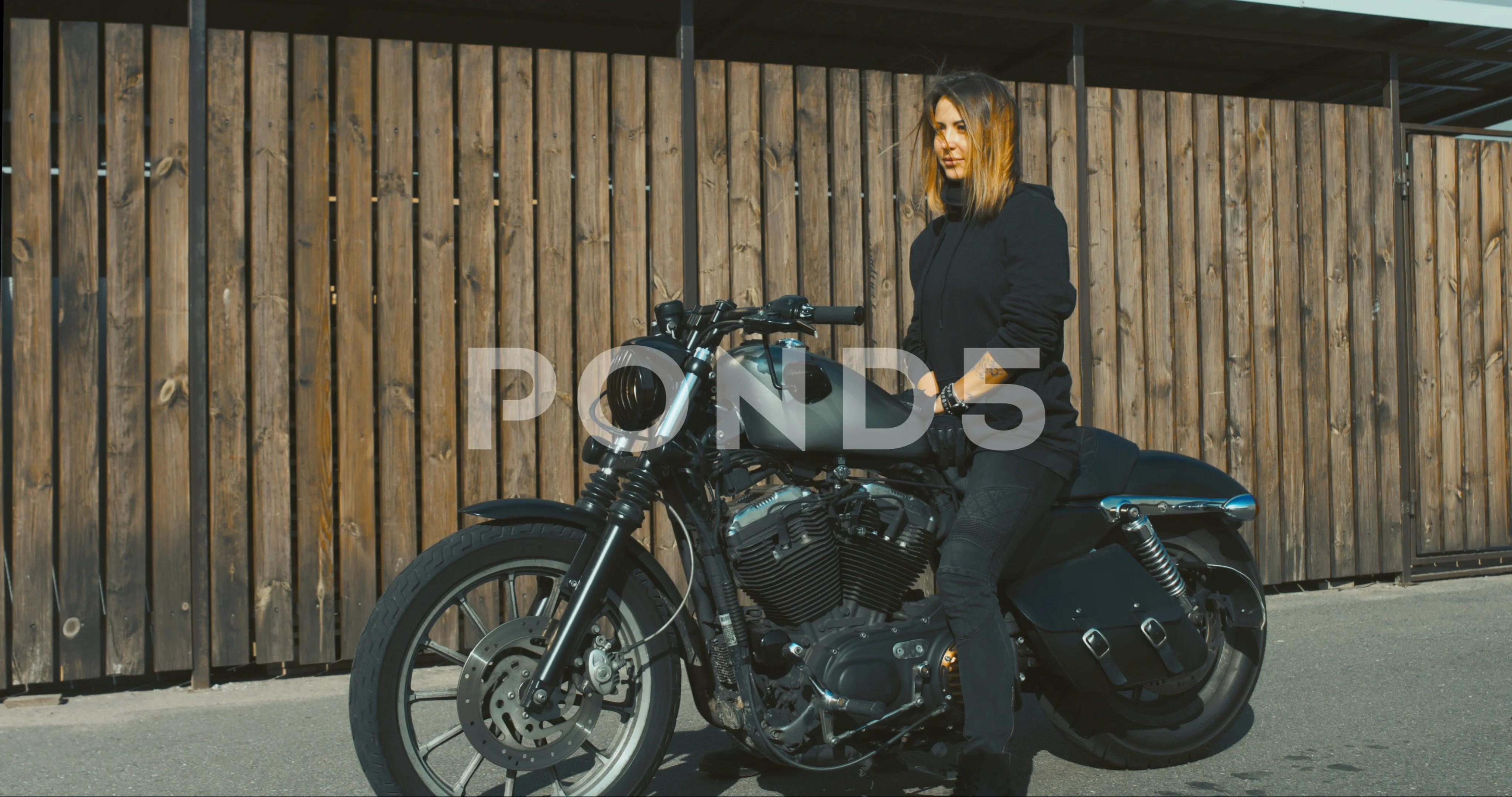 CINEMAGRAPH Sexy biker girl wearing leather jacket sits on a modern  motorcycle