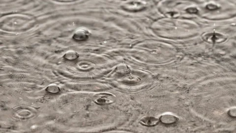Cinemagraph slow motion loop of Rain Drops On The Water puddle Video stock 153237495