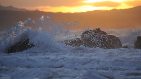 Cinemagraph slow motion loop of wave crashing at sunset Stock Footage 151918131