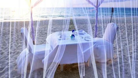 Cinemagraph of sunset beach dinner settings Stockbeeldmateriaal 88555377