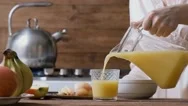 Cinemagraph - Young Woman Pouring The Orange Juice Into A Glass. Stock Footage