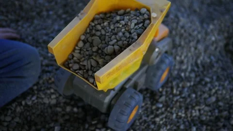 Cinemat Shot of Boy Loading Rocks into Play  Dumptruck Stock Footage 347033973