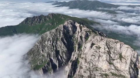 Cinematic 4K UHD Drone Flight Over Rugged Rocky Mountains Above a Sea of Clouds. Stock Footage 342066385
