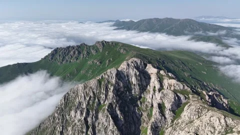 Cinematic 4K UHD Drone Flight Over Rugged Rocky Mountains Above a Sea of Clouds. Stock Footage 342066395