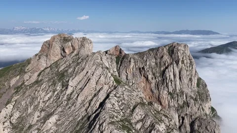 Cinematic 4K UHD Drone Flight Over Rugged Rocky Mountains Above a Sea of Clouds. Stock Footage 342066646