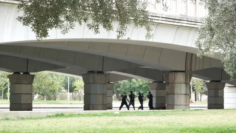 Cinematic 4k UHD group of men practicing karate in the background under a bridge Stock Footage 75308726
