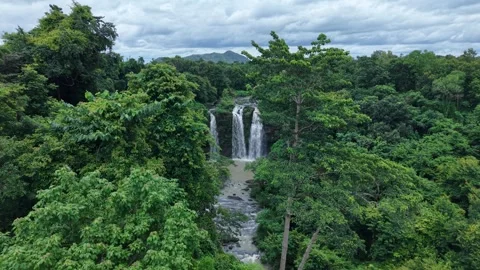 Cinematic aerial approach to a three-stream waterfall Stock Footage 342209931